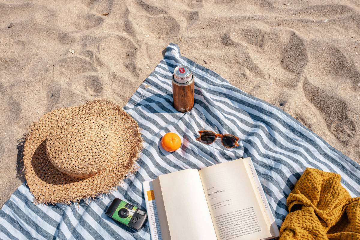 Book, Hat on a mat at beach